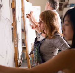 a few art students painting using a easel
