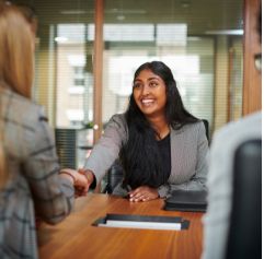 young woman at a job interview shaking the interviewer's hand