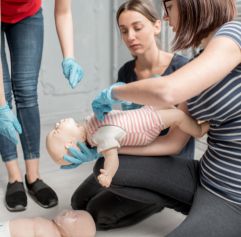 students performing CPR on a dummy baby
