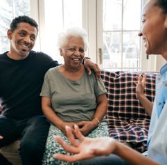 older couple sitting and talking with younger adult