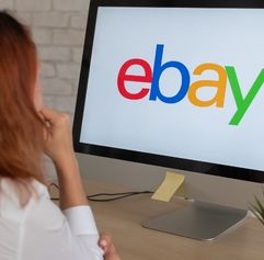 woman in front of a computer screen that says eBay on it