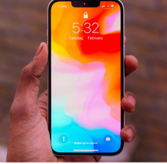 a hand holding an iPhone with the home screen on it