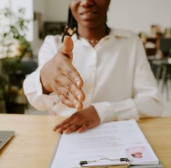 a close up of a woman holding out her hand to shake it with her new employer