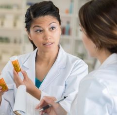 two female pharmacy employees talking about a perscription