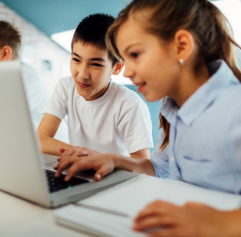 two kids looking at a computer screen