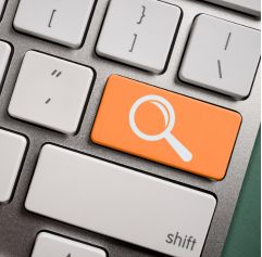 a computer keyboard with a button that has a magnifying class on it