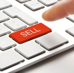 sell button on a keyboard and a person pressing it