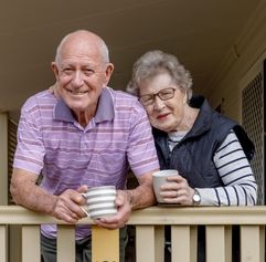 an older couple on the porch of their home