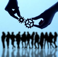 two hands holding gears that fit together