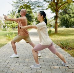 two adults practicing tai chi outdoors