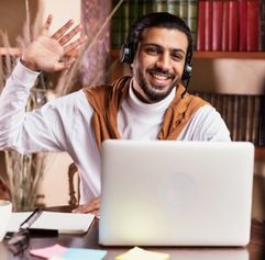 man with headphones on in front of a computer
