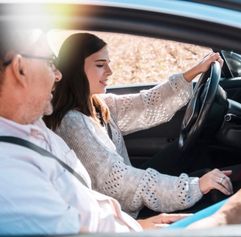 a teen learning to drive with an adult in the car
