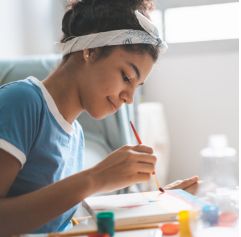 a close up of a teen girl painting